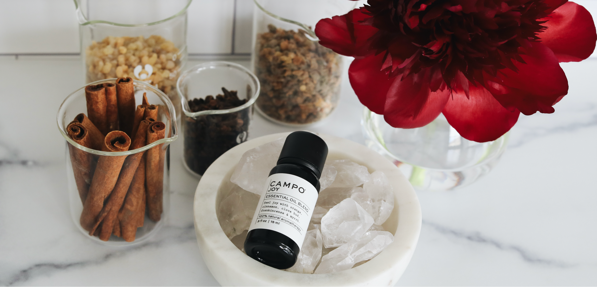 Bottle of Campo Beauty JOY Pure Essential Oil blend with ingredients on a marble countertop 